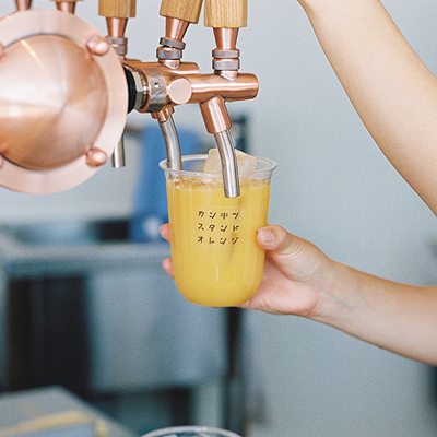 写真:オレンジジュースがサーバーから注がれています