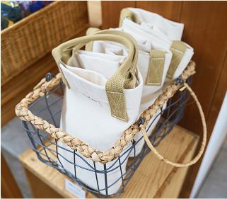 オリジナルトートバッグが鉄の網カゴに入っています