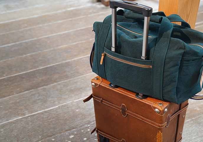 写真:革のトランクケースの上にカバンが乗っています